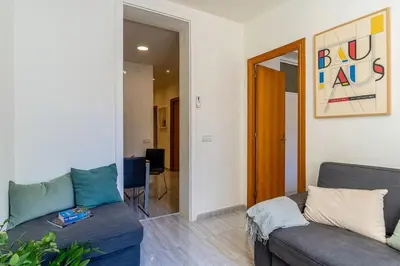 a living room with a couch and a chair at Canela Homes BARCELONA ARC DE TRIOMF in Barcelona