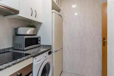 a kitchen with a microwave and a washer and dryer at Canela Homes BARCELONA ARC DE TRIOMF in Barcelona