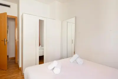 a bedroom with a white bed with two pillows on it at Stay U-nique Apartments Bonsoms in Barcelona