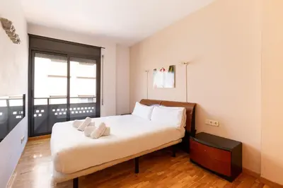 a bedroom with a bed with white sheets and a window at Stay U-nique Apartments Bonsoms in Barcelona