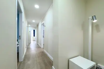 a hallway with white walls and wooden floors at Habitación 1 NOU DE LA RAMBLA in Barcelona