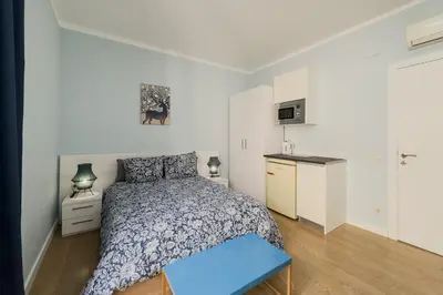 a bedroom with a bed and a small kitchen at Habitación 1 NOU DE LA RAMBLA in Barcelona