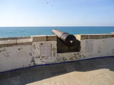a cannon on a wall next to the ocean at Apartment Dolce Vita lovely in Sitges
