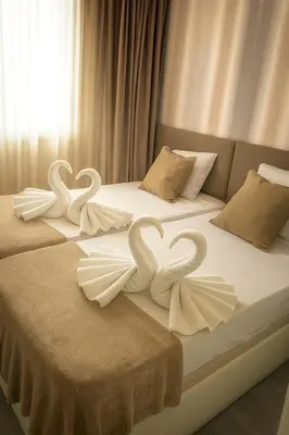 two swansrendered to look like hearts sitting on two beds at Luz y Mar II in Barcelona
