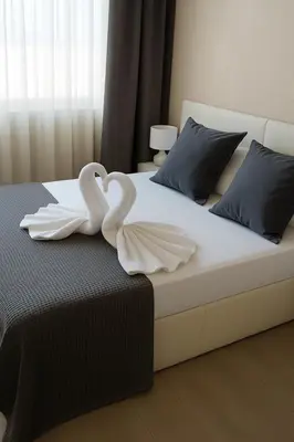 two swans are sitting on top of a bed at Luz y Mar II in Barcelona