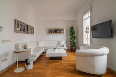 a living room with white furniture and a flat screen tv at Stay U-nique Apartment Creu Coberta II in Barcelona