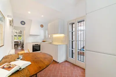 a kitchen with a wooden table in a room at Casa Alba Garden & Calm in Sitges