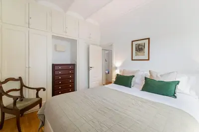 a bedroom with a bed with green pillows and a chair at Casa Alba Garden & Calm in Sitges