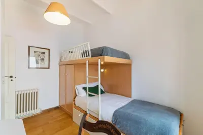 a bedroom with a bunk bed with a blue blanket at Casa Alba Garden & Calm in Sitges
