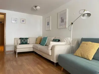 a living room with two couches and a lamp at Apartamento con jardín cerca playa y a 15 min de Plaza Catalunya en tren in Sant Adria de Besos