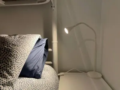 a bedroom with a bed with a blue pillow and a lamp at Apartamento con jardín cerca playa y a 15 min de Plaza Catalunya en tren in Sant Adria de Besos