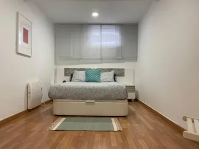 a bedroom with a bed in a white room at Apartamento con jardín cerca playa y a 15 min de Plaza Catalunya en tren in Sant Adria de Besos