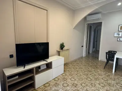 a living room with a flat screen tv on a cabinet at Gran Via Green in Barcelona