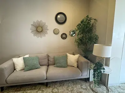 a living room with a couch and clocks on the wall at Gran Via Green in Barcelona