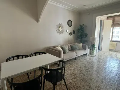 a living room with a couch and a table and chairs at Gran Via Green in Barcelona