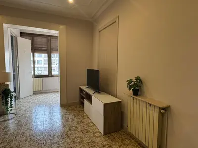 a living room with a flat screen tv on a cabinet at Gran Via Green in Barcelona