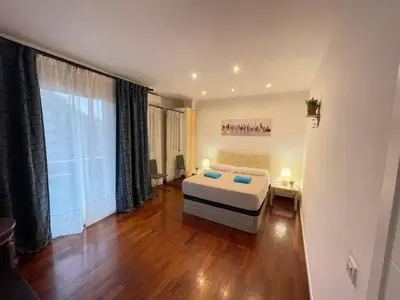 a bedroom with a bed with two blue pillows on it at Alojamento París 50 in Barcelona