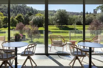 a room with tables and chairs and a large window at Hotel Món Sant Benet in Sant Fruitos de Bages