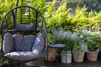 a chair sitting on a deck with plants at Infinity House in Cabrera de Mar