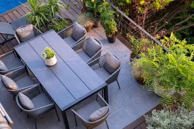 a wooden table and chairs in a garden at Infinity House in Cabrera de Mar