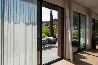 a sliding glass door leading to a patio with a table at Infinity House in Cabrera de Mar