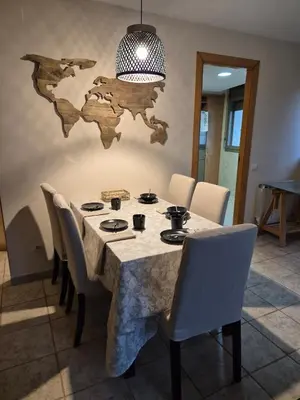 a dining room with a table with white chairs at Gran terrassa al cantó del mar in Canet de Mar