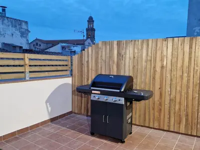 a grill sitting on the side of a fence at Gran terrassa al cantó del mar in Canet de Mar