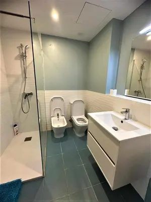 a bathroom with two toilets and a sink and a shower at Acogedoras habitaciones Sepulveda in Barcelona