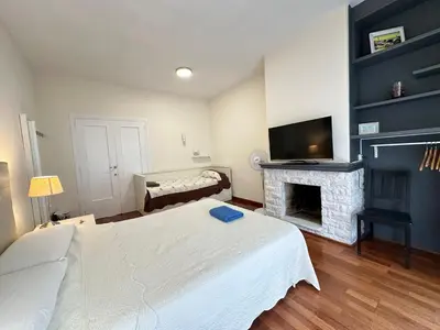 a bedroom with a white bed and a fireplace at Apartamento en Viladomat in Barcelona