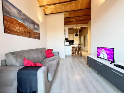 a living room with a couch and a flat screen tv at Bogatell Playa Apartment in Barcelona