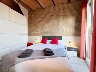 a bedroom with a large bed with red pillows at Bogatell Playa Apartment in Barcelona