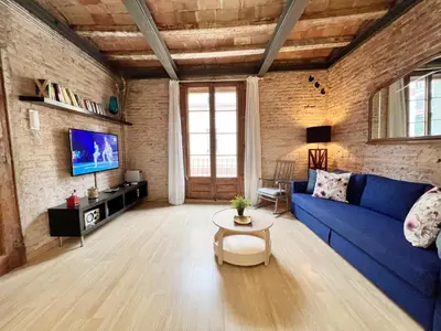 a living room with a blue couch and a tv at Casa de las Flores Barcelona in Barcelona