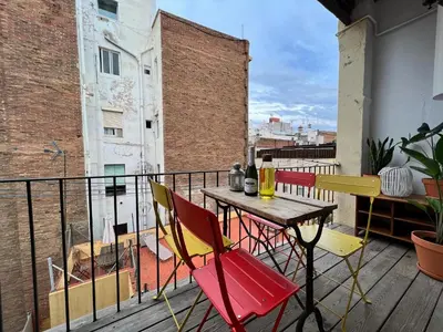 a balcony with a table and chairs on a roof at Casa de las Flores Barcelona in Barcelona