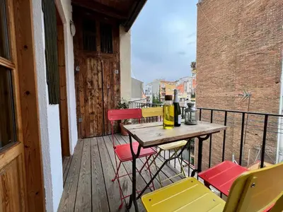 a porch with a table and chairs on a balcony at Casa de las Flores Barcelona in Barcelona