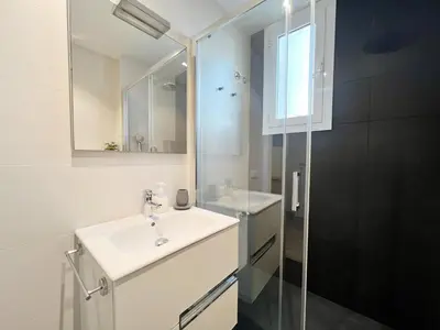a bathroom with a sink and a glass shower at Pamplona Playa Apartment in Barcelona