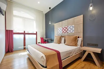 a bedroom with a king sized bed and a window at Boutique Hostemplo Sagrada Familia in Barcelona