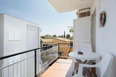 a balcony with a white table and a white chair at Stay U-nique Apartments Sitges Beach in Sitges