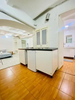a kitchen with white cabinets and a wooden floor at 11 Principal Barca in Barcelona