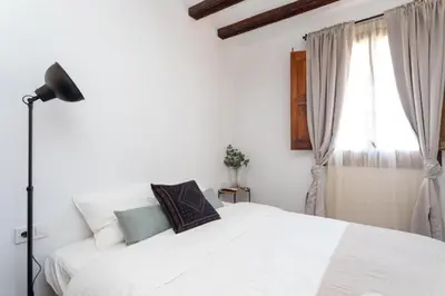 a bedroom with a white bed and a window at Sunshine Studios Portside Gothic in Barcelona