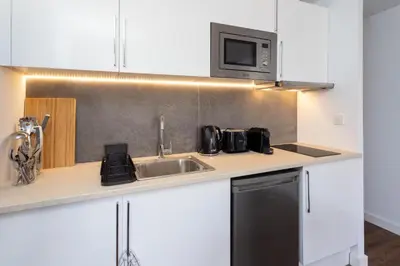 a kitchen with a sink and a microwave at Sunshine Studios Portside Gothic in Barcelona
