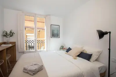 a bedroom with a large white bed with a window at Sunshine Studios Portside Gothic in Barcelona