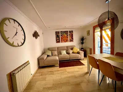a living room with a couch and a clock on the wall at Precioso y espacioso piso in Arenys de Mar