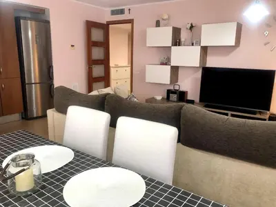 a living room with a couch and a table and chairs at Vivalidays - Estrella de Mar - Calella in Calella