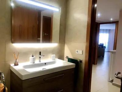 a bathroom with a white sink and a mirror at Vivalidays - Estrella de Mar - Calella in Calella