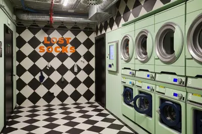 a laundry room with two washing machines and a checkered floor at The Social Hub Barcelona Poblenou Extended Stay in Barcelona