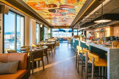 a restaurant with a bar with tables and chairs at The Social Hub Barcelona Poblenou Extended Stay in Barcelona