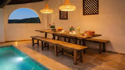 a dining room with a table and benches next to a pool at Masia La Morera autenticidad renovada 100 porcien a 10 minutos de Sitges en coche 12 huespedes Piscina Aire Aconc 6 Suites Apertura 15 Julio 2025 in Viladellops