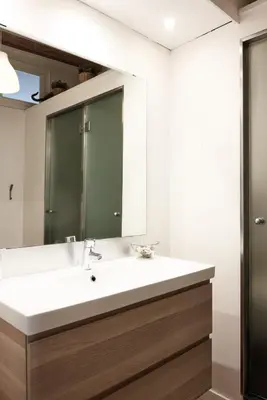 a bathroom with a sink and a mirror at Sunny apartment on the square in Barcelona