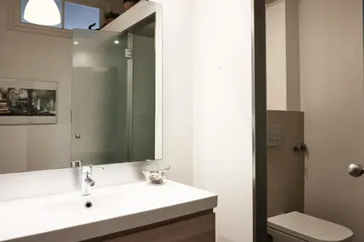 a bathroom with a sink and a mirror at Sunny apartment on the square in Barcelona