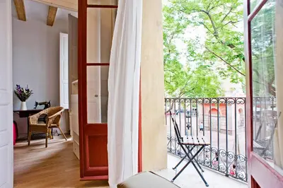 a room with a balcony with a view at Sunny apartment on the square in Barcelona